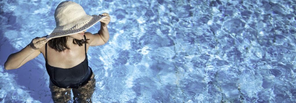 girl stands pool with large straw hat black swimsuit top view 1024x358 - La limpieza de la piscina en la comunidad